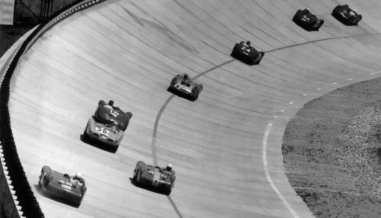Historic racing cars on the Monza banking, representing the origins of the Massa racing dynasty.